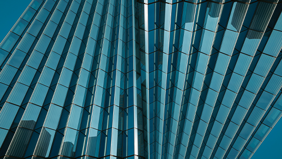 Blue glass panels on a building, arranged in a repeating geometric pattern.